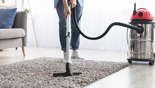 Young casual lady using vacuum cleaner | Carpet Town